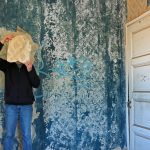 man with torn wallpaper